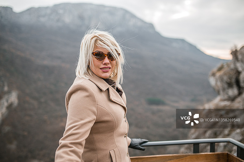 微笑的美女站在山顶上图片素材