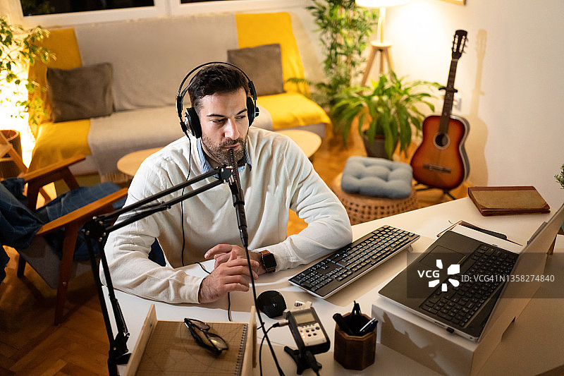 专注的现代男人在家里的工作室主持广播频道图片素材