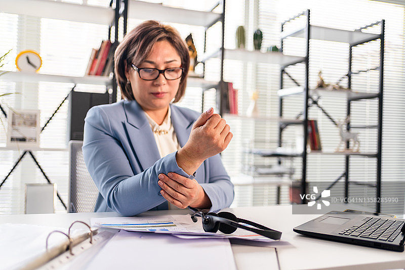 痛苦地抓住手腕的女人图片素材