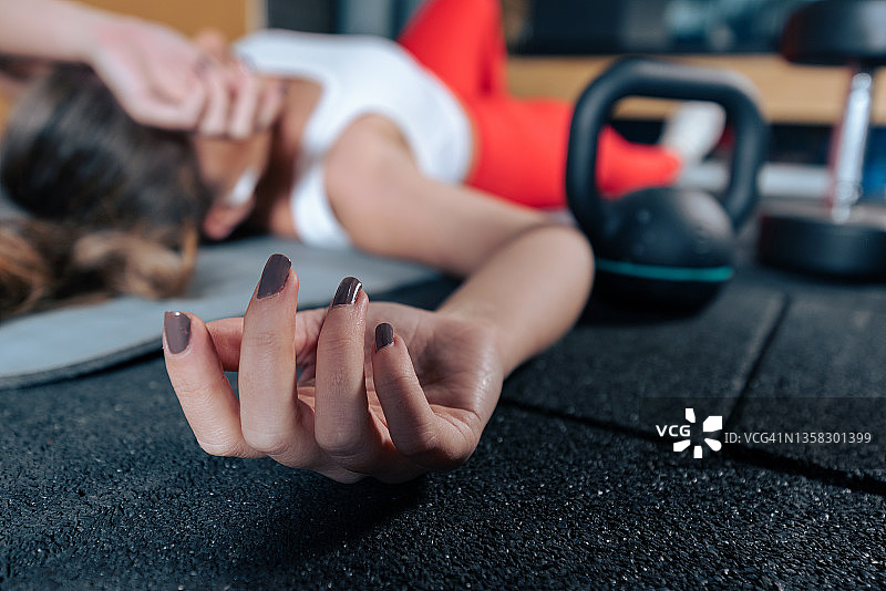 年轻女子在极限运动后疲惫地躺在地板上图片素材