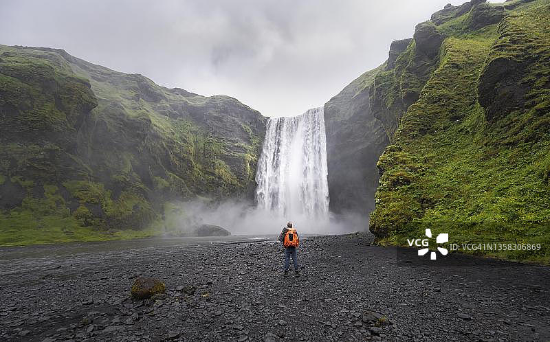 徒步者在冰岛南部斯科加瀑布前图片素材