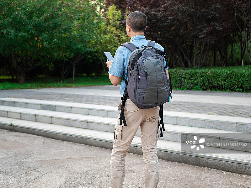 使用手机搜索信息的背包客图片素材