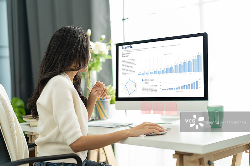 年轻亚洲女性在家工作，在电脑上获得新想法图片素材