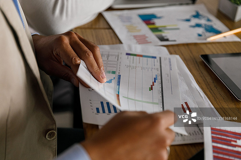 在办公桌前查看项目报告的商人图片素材