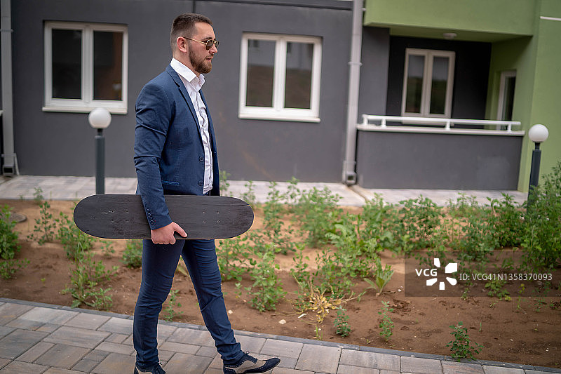 在街上踩滑板移动的商人图片素材