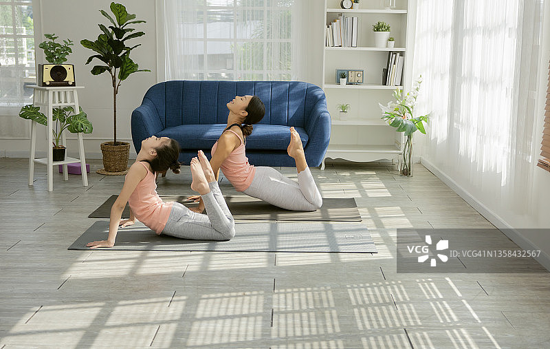 母亲在家和女儿一起做瑜伽图片素材