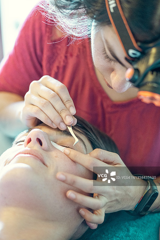 美容师在家为顾客贴假睫毛图片素材