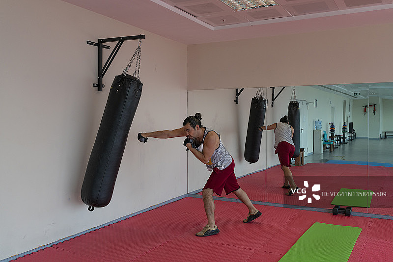 在健身房用运动器材锻炼的男人图片素材