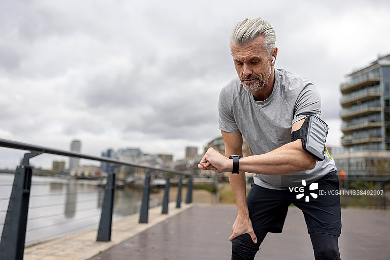 男人跑步时看智能手表图片素材