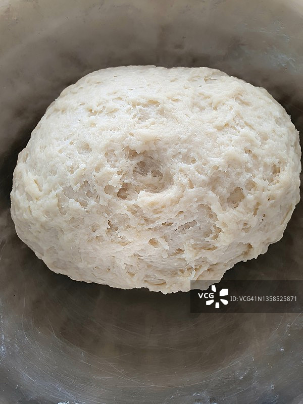 不锈钢搅拌碗中发酵的面团图片素材