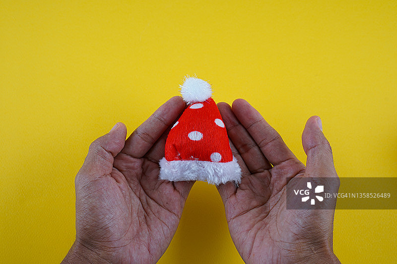 手持红色圣诞老人帽子，带复制空间图片素材