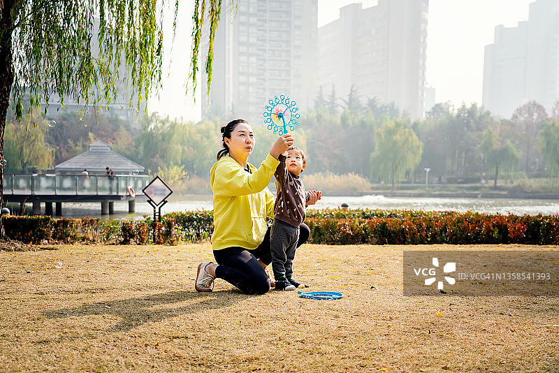 在公园里玩耍的年轻亚洲母亲和儿子图片素材