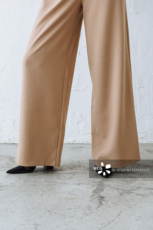 穿裤子和鞋子的女模特在工作室的腿部图片素材