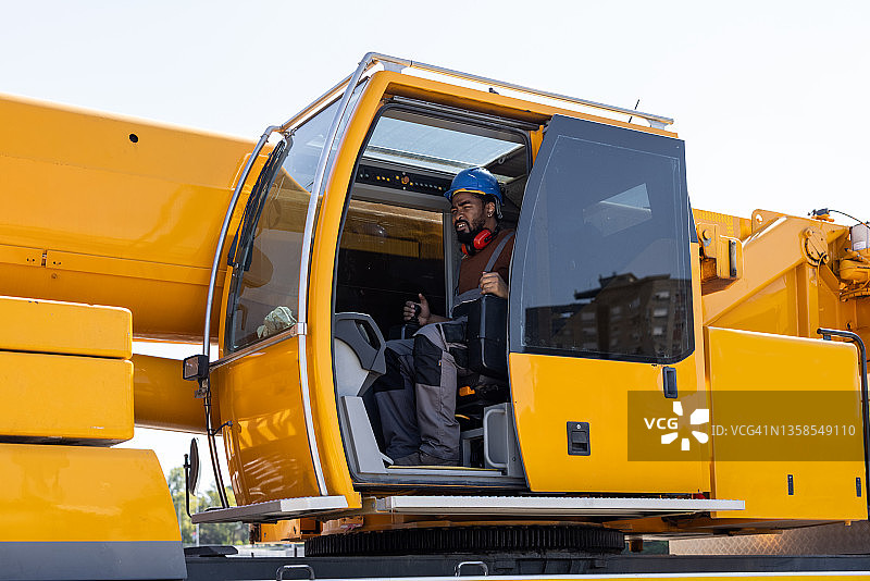 在工程机械中的年轻建筑工人肖像图片素材