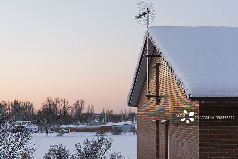 日出时被雪覆盖的屋顶房屋图片素材