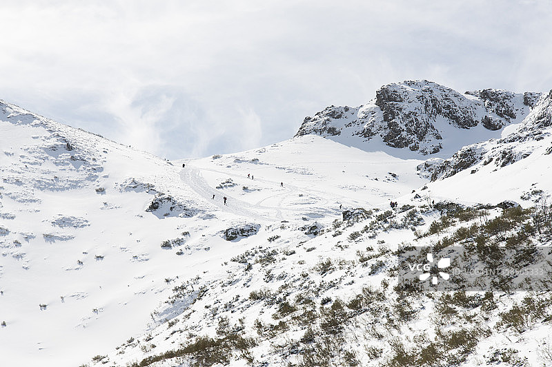 在西班牙欧洲之峰白雪皑皑的山上滑雪的人们图片素材