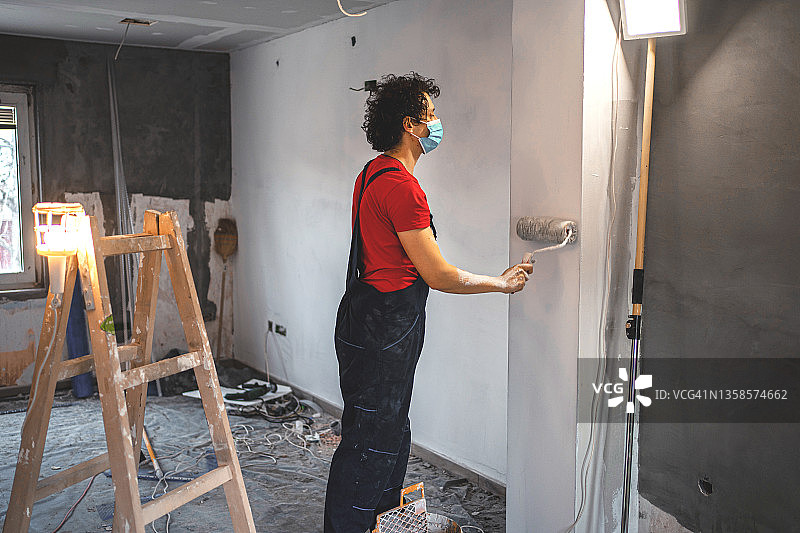 粉刷公寓墙壁的建筑工人图片素材