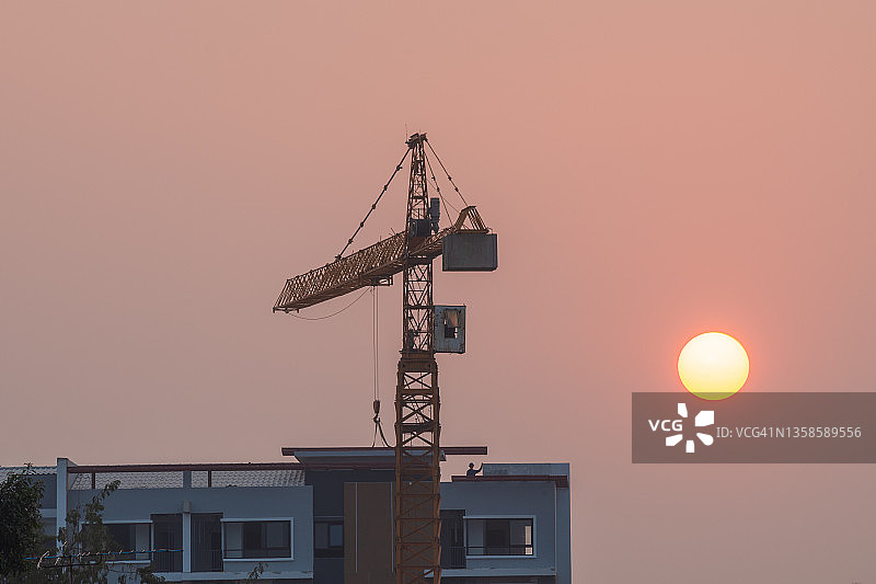 建筑工地，起重机在美丽的日落时分工作图片素材