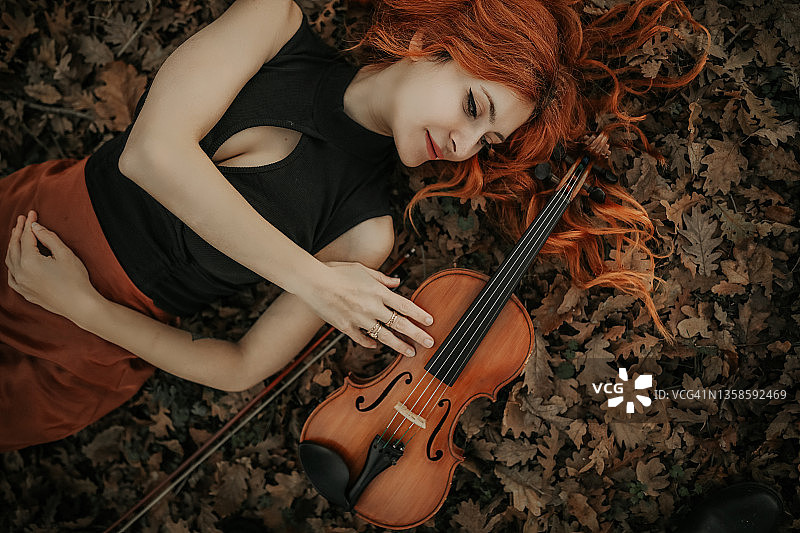 女人生活方式，小提琴，红发音乐家女人图片素材