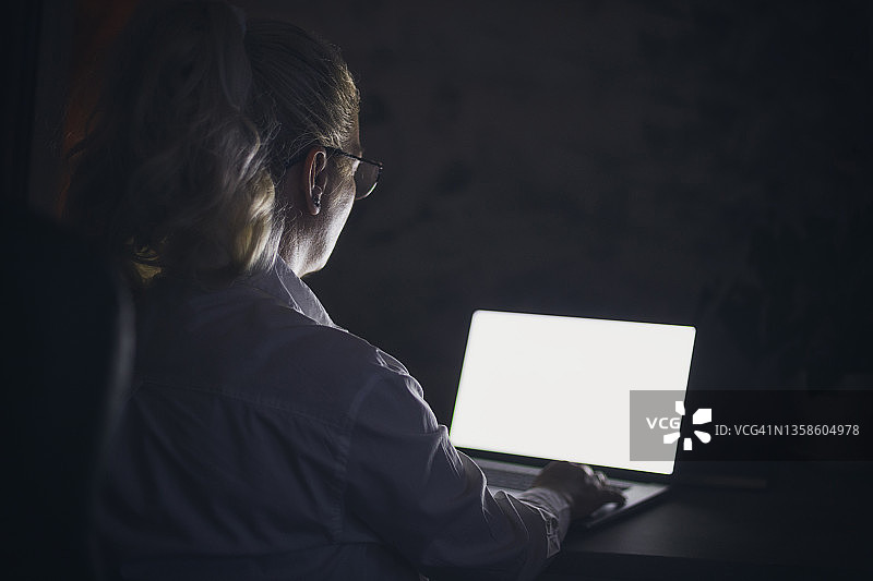 在办公室深夜用笔记本电脑工作的女人图片素材