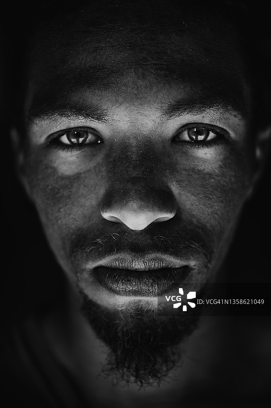 年轻混血男性的黑白面部特写，绿眼睛和脏辫图片素材