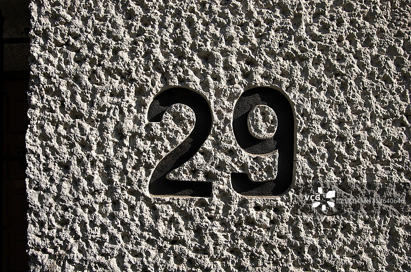 白色粉刷的灰泥墙上压印的29号街牌地址图片素材