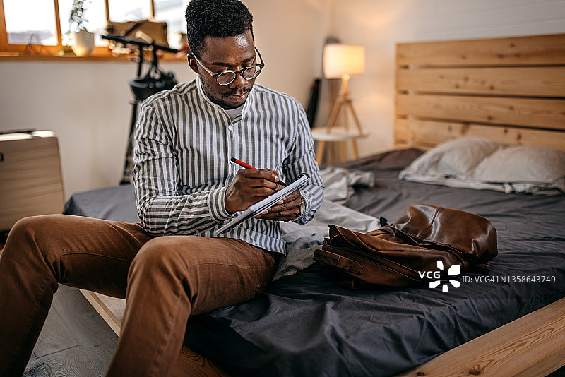 男人在家里的房间里看书写作图片素材
