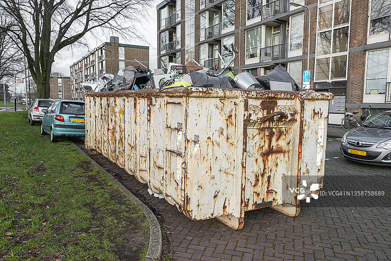 装满各种生活垃圾的大型钢制垃圾箱图片素材