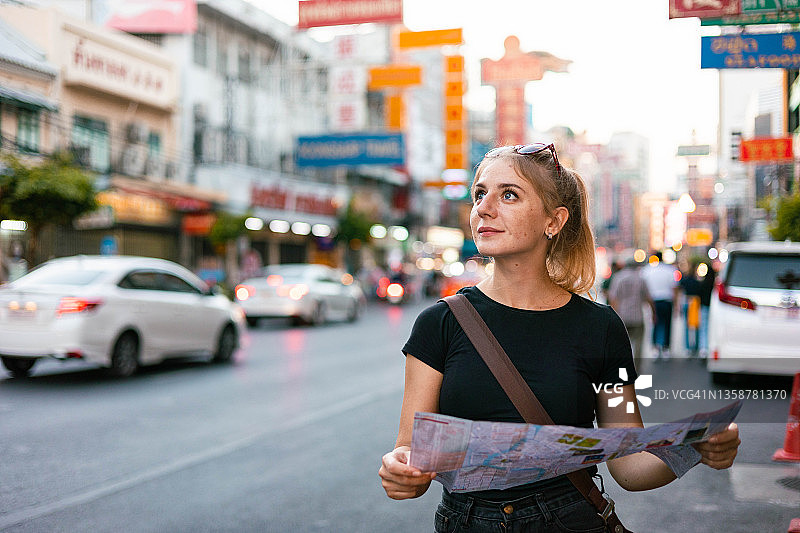 在泰国曼谷耀华力路户外市场看地图的年轻单身旅行女性图片素材