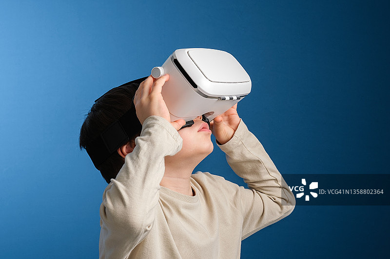 在彩色背景上使用VR眼镜的可爱儿童图片素材
