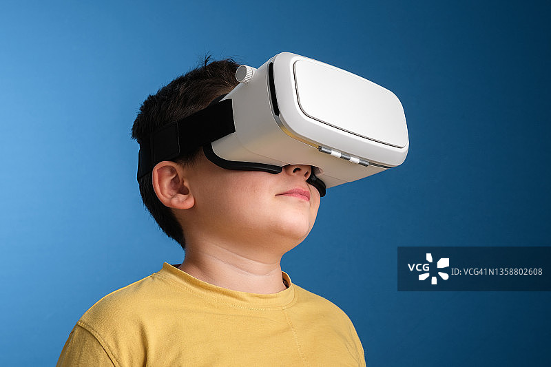 在彩色背景上使用VR眼镜的可爱儿童图片素材