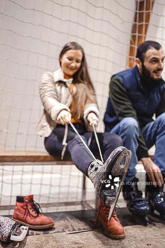 年轻夫妇系冰鞋鞋带图片素材