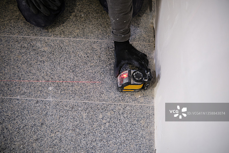 建筑工人在建筑工地用激光水平仪进行测量图片素材