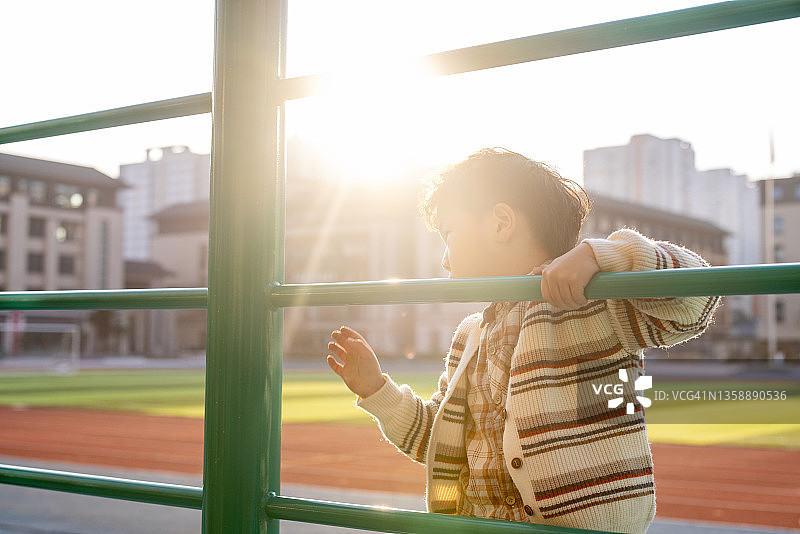 小男孩在学校操场上做运动图片素材