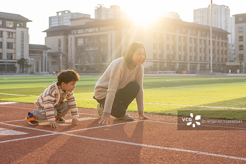 母子在学校操场上跑步图片素材