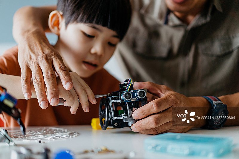 父子在家组装机器人玩具图片素材