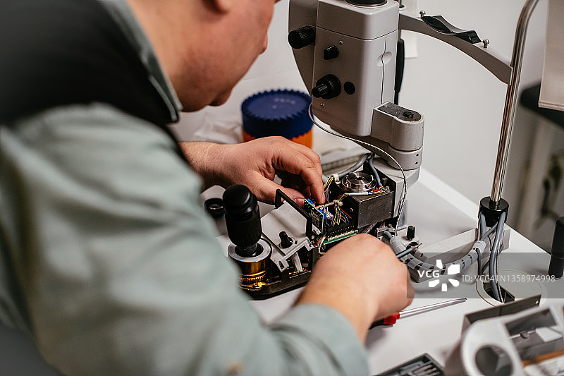 技术员正在维修眼科治疗显微镜图片素材