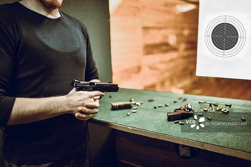 男射击手准备装填手枪，开始在射击场上练习图片素材