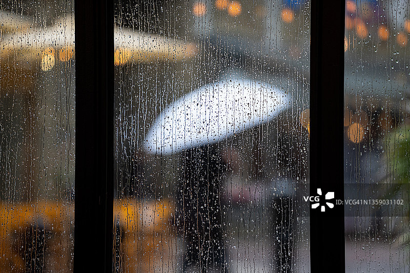 暴风雨中，透过窗户上的雨滴向外看图片素材