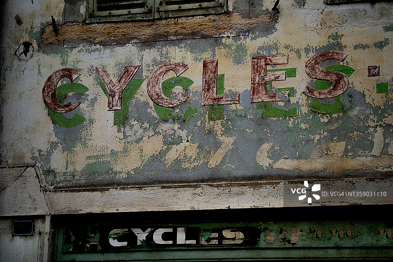废弃建筑物上褪色的自行车店招牌图片素材