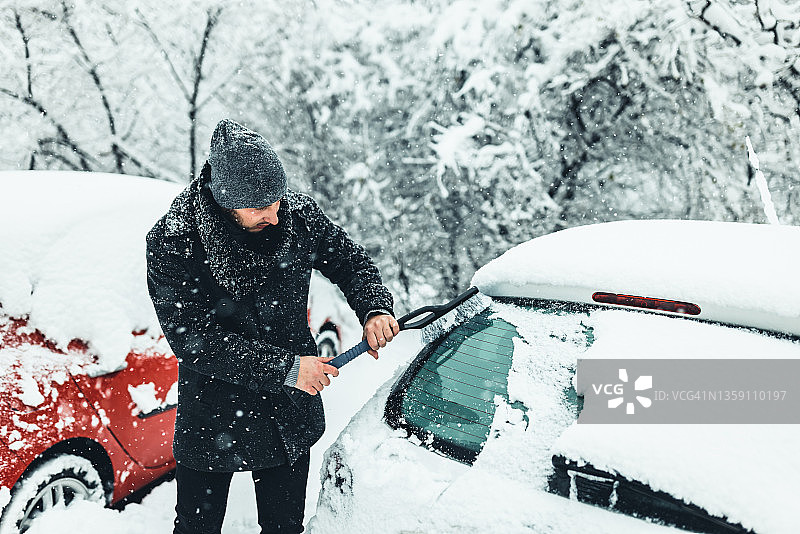 年轻男人清理车窗玻璃上的冰图片素材