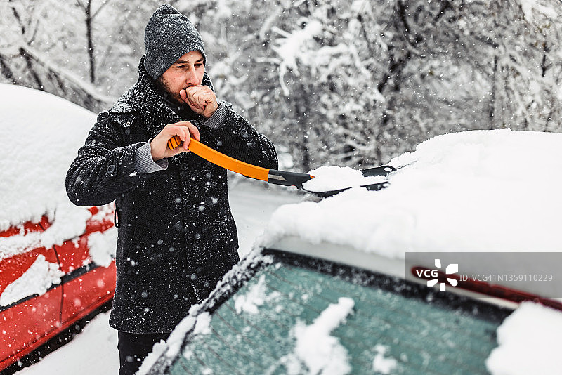 雪后用铲子清理汽车的男人图片素材