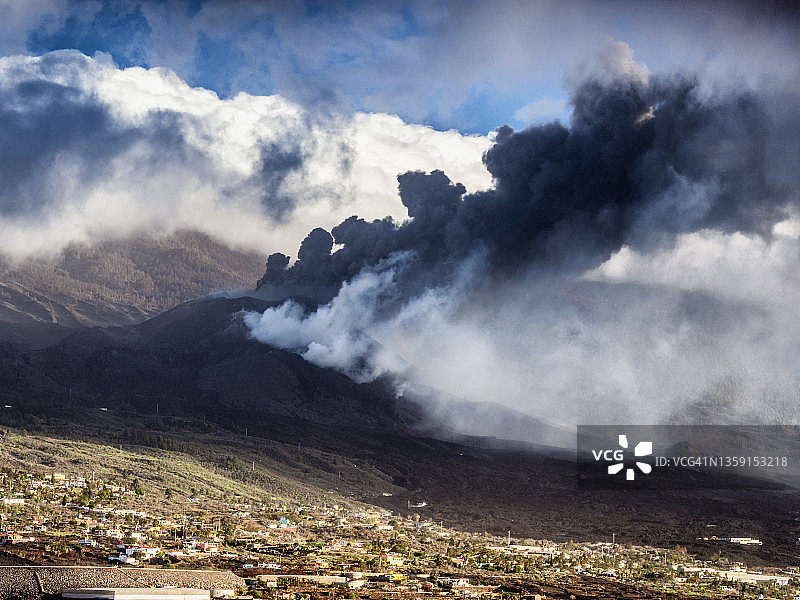 火山在城镇房屋旁喷发：拉帕尔马岛老峰火山图片素材