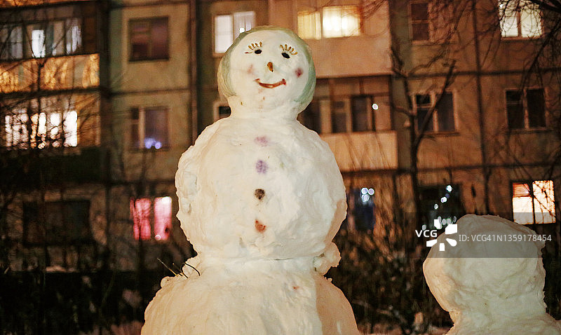 夜晚城市建筑背景下的有趣雪人图片素材