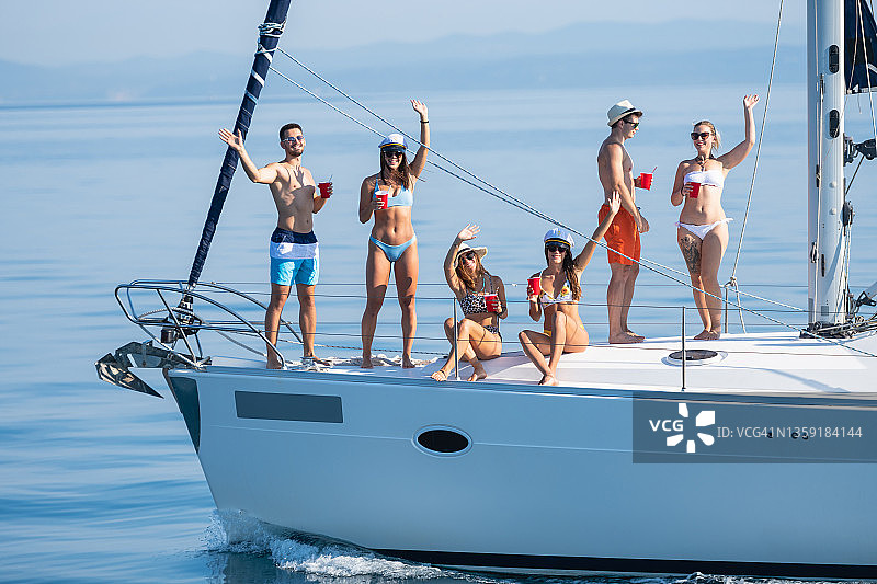 一群朋友挥手享受航海乐趣图片素材