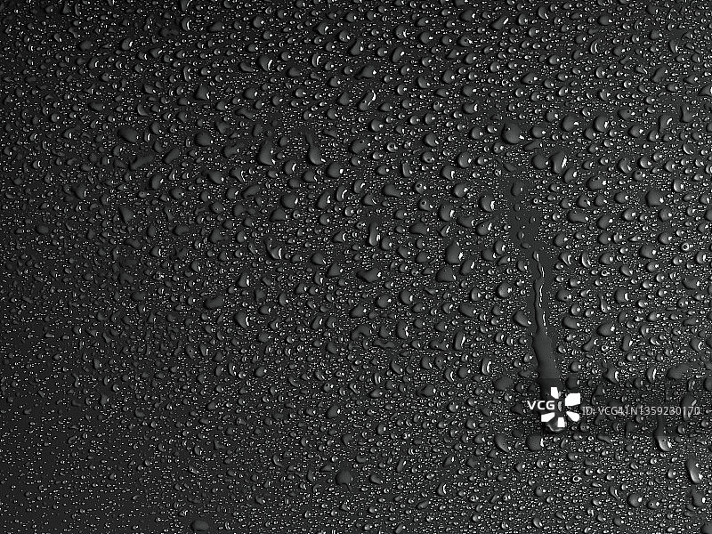 黑色湿表面上的水滴图片素材