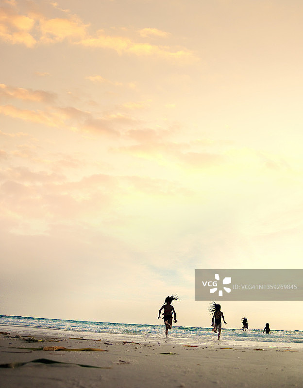 孩子们在海滩度假时奔向大海图片素材