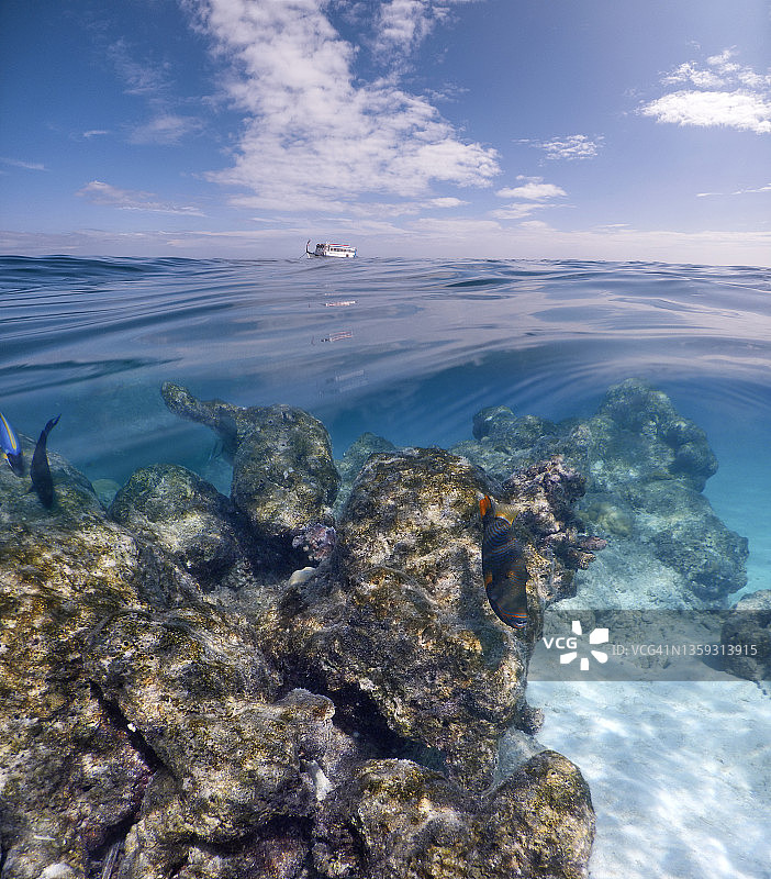 马尔代夫珊瑚礁与多尼船的双层景观图片素材
