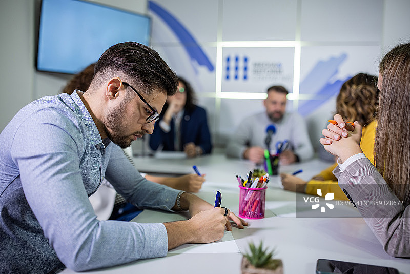 记者在媒体中心的新闻发布会上做笔记图片素材