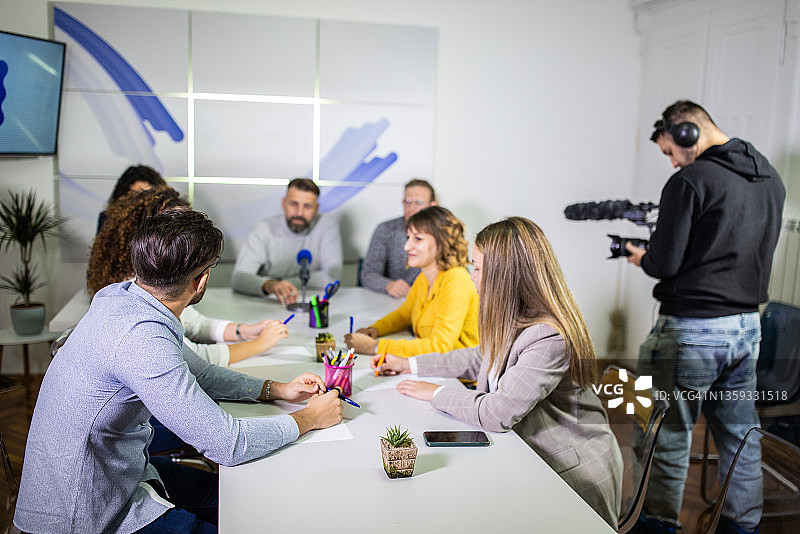 在医疗中心拍摄新闻发布会的摄影师图片素材